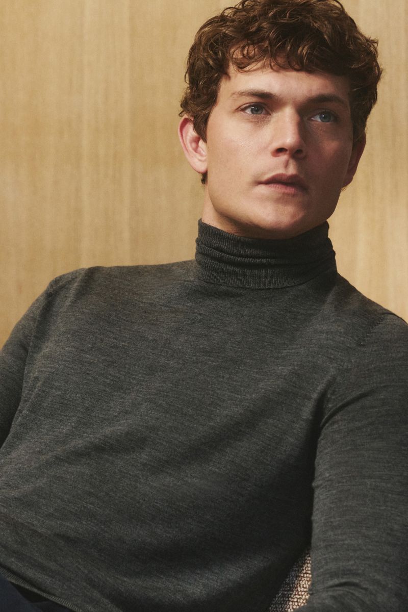 Männliches Modell von schräg vorne, trägt von Braun Merino Rollkragenpullover anthrazit meliert, Slim Fit, reine Merinowolle.
