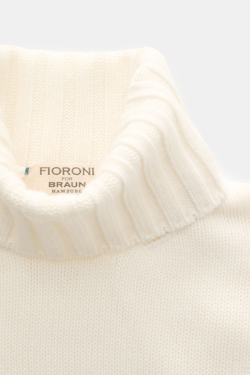 Close-up front view of Fioroni Cashmere Rundhalspullover creme, showcasing its soft, ribbed turtleneck collar and fine knit texture.

Souveräne Eleganz in ihrer luxuriösesten Form: Der Rollkragenpullover von FIORONI aus erlesenem Cashmere vereint meist