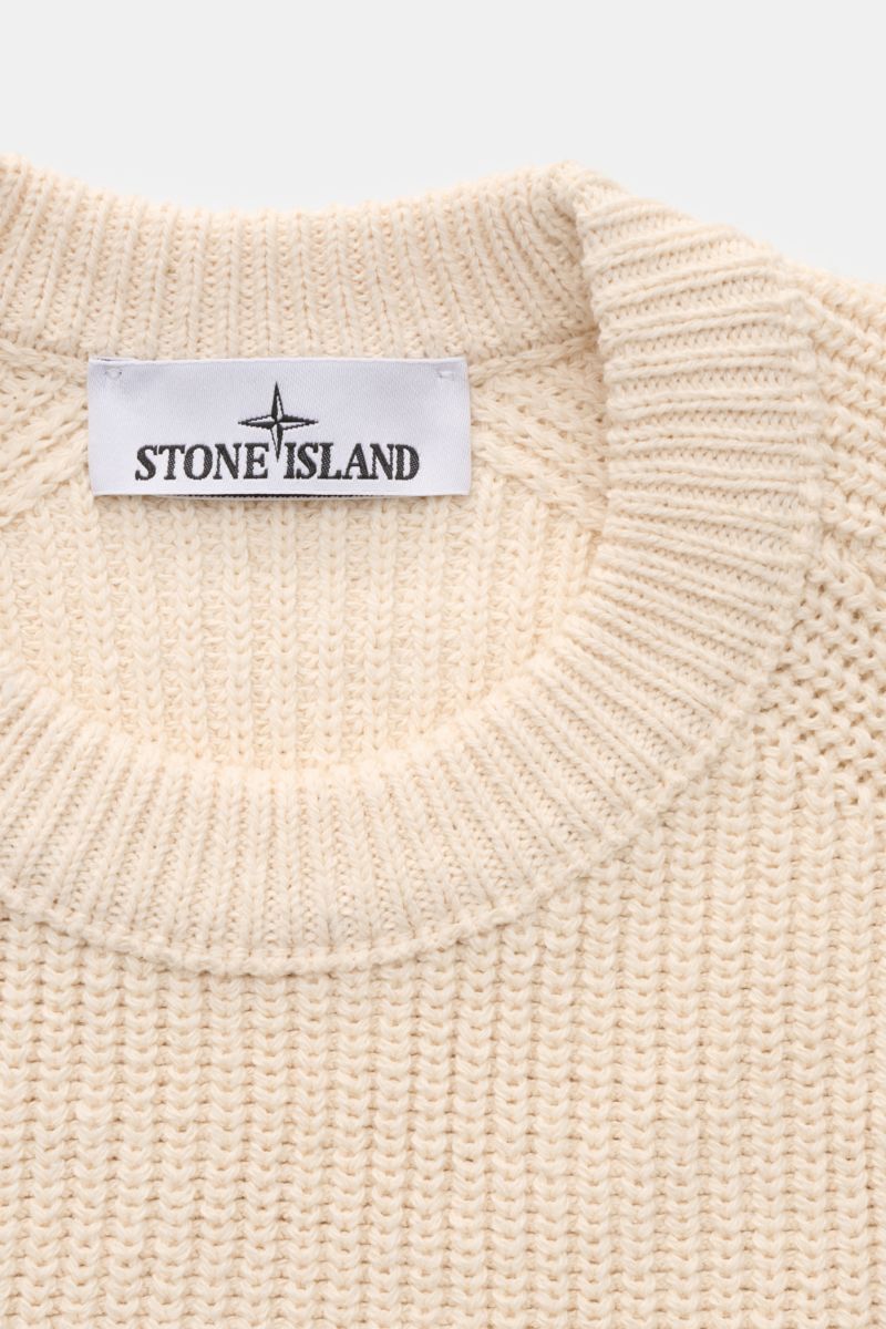 Stone Island Rundhalspullover 'Raw Beauty' creme shown from a close-up top-down view, featuring patent cotton knit, slim fit, round neckline, and typical compass badge.

Der Rundhalspullover 'Raw Beauty' von STONE ISLAND im Patentstrick wurde aus reine