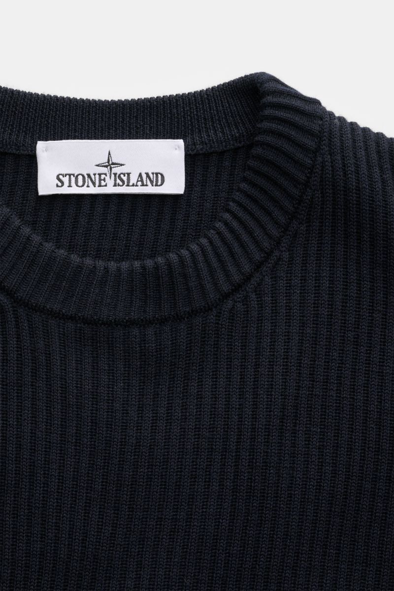 Close-up front view of Stone Island Rundhalspullover 'Full Rib' navy showing ribbed round neckline and knit texture.

Stylishes Essential für die kalte Jahreszeit: Dieser lässige Pullover von STONE ISLAND aus reiner, RWS-zertifizierter Schurwolle überz