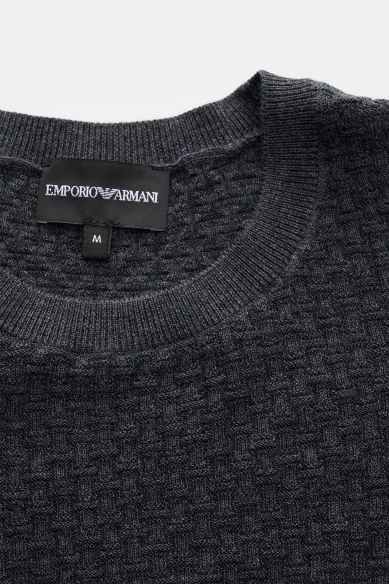 Close-up front view of Emporio Armani Feinstrick-Rundhalspullover dunkelgrau, showing finely textured dark gray pure virgin wool knit with soft feel, regular fit, round neckline, tonal logo stitching, and comfortable ribbed cuffs.

Angenehm weich, leic