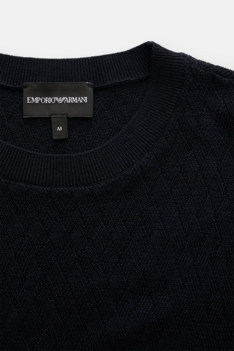 Close-up front view of the Emporio Armani Feinstrick-Rundhalspullover dark navy in pure virgin wool, featuring a soft touch, tonal diamond knit pattern, slim fit, round neckline with sweater detail, logo intarsia on the chest, and comfortable ribbed cuffs