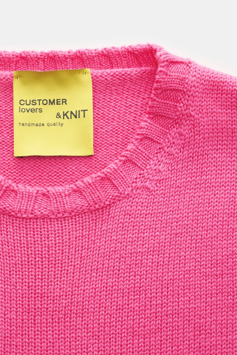 Nahaufnahme von B.F. Knitwear Merino Rundhalspullover magenta aus reine Merinowolle, weicher Griff, mittelgrobes Strickbild, Slim Fit, Rundhalsausschnitt, breite Rippstrick-Bündchen.
