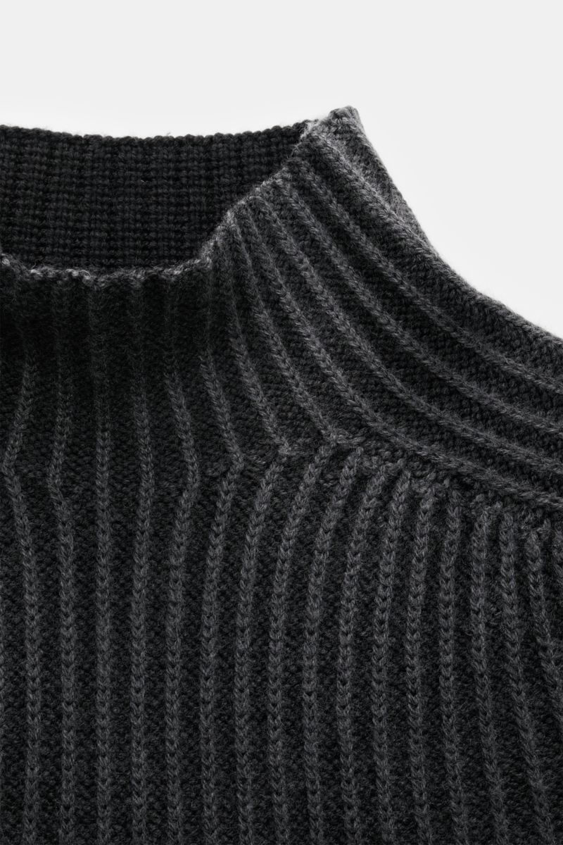 Nahaufnahme des schwarzen 04651/ A trip in a bag Mock Neck Pullover 'Foggy Mock' mit Stehkragen, grobem Rippstrick und weichem Griff aus reiner Wolle, fotografiert von oben.