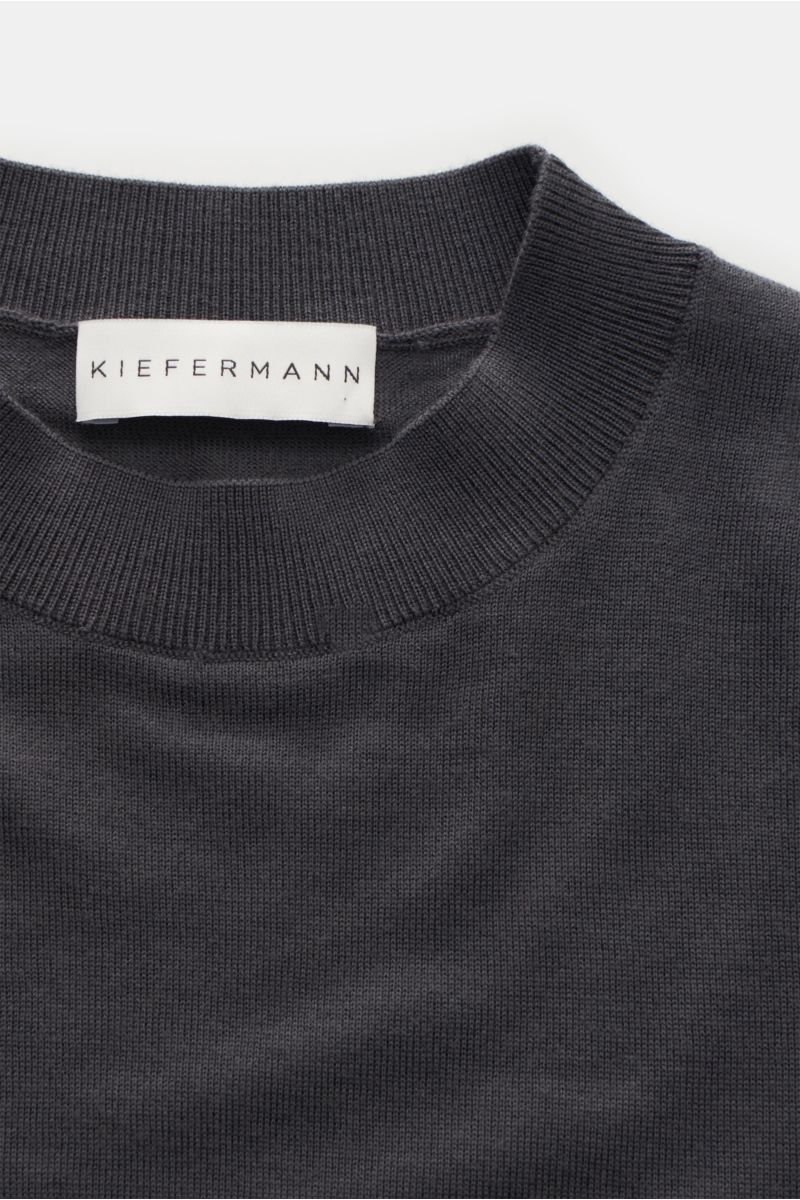 Nahaufnahme des Kiefermann Merino Feinstrick-Pullovers dunkelgrau mit hohem Rundhalsausschnitt, Slim Fit, elastischen Ärmelabschlüssen, sehr feinem Strickbild, superweichem Griff aus reiner Merinowolle.