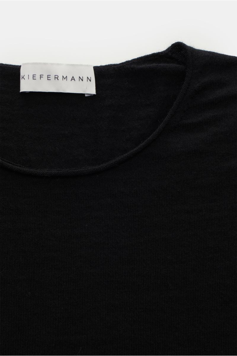 Kiefermann Merino Feinstrick-Pullover 'Benjaminn' schwarz in Nahaufnahme von oben, reine Merinowolle, superweicher Griff, sehr feines Strickbild, Slim Fit, Rundhalsausschnitt, offene, rollierte Kantenabschlüsse.