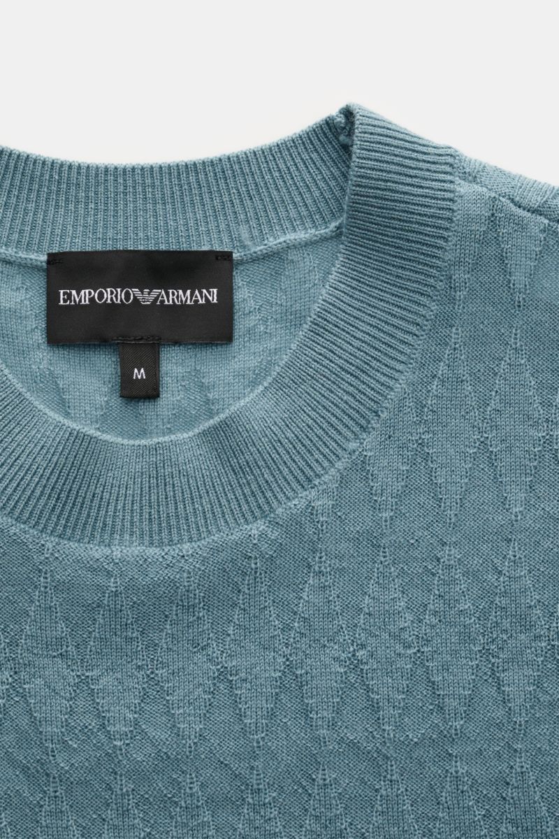 Close-up front view of the Emporio Armani Rundhalspullover rauchblau in light pure wool with subtle diamond texture, round neckline, ribbed cuffs, and branded label at hem. 

Vielseitiger Begleiter: Der leichte Rundhalspullover aus reiner Schurwolle vo