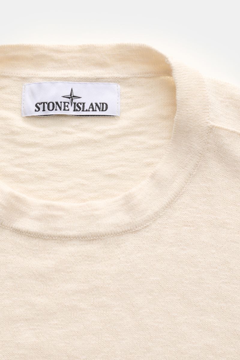 Stone Island Rundhalspullover creme, Slim Fit mit Rundhalsausschnitt, feinem Strickbild, rolliertem Saum und Kompass-Badge, Nahaufnahme von oben.
