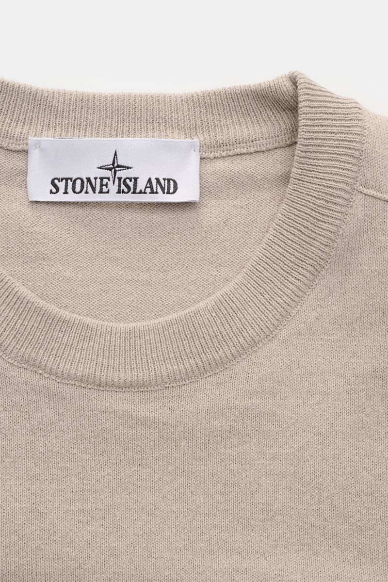 Stone Island Rundhalspullover hellgrau, Slim Fit, aus reiner Baumwolle mit feinem Strickbild, rolliertem Saum, Rundhalsausschnitt, Kompass-Badge, Detailansicht von oben.