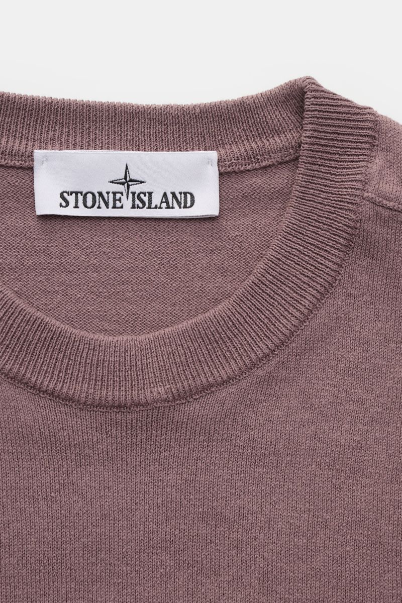 Stone Island Rundhalspullover flieder in Slim Fit, aus reiner Baumwolle mit rolliertem Saum, Rundhalsausschnitt, feinem Strickbild, Kompass-Badge, Nahaufnahme von oben.