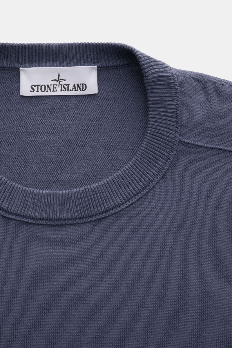 Close-up front top view of Stone Island Crew neck jumper smoky blue, showcasing fine knit cotton fabric and ribbed collar.

Description: Timeless classic: This knitted jumper by STONE ISLAND is a casual spring companion thanks to its comfortable cotton