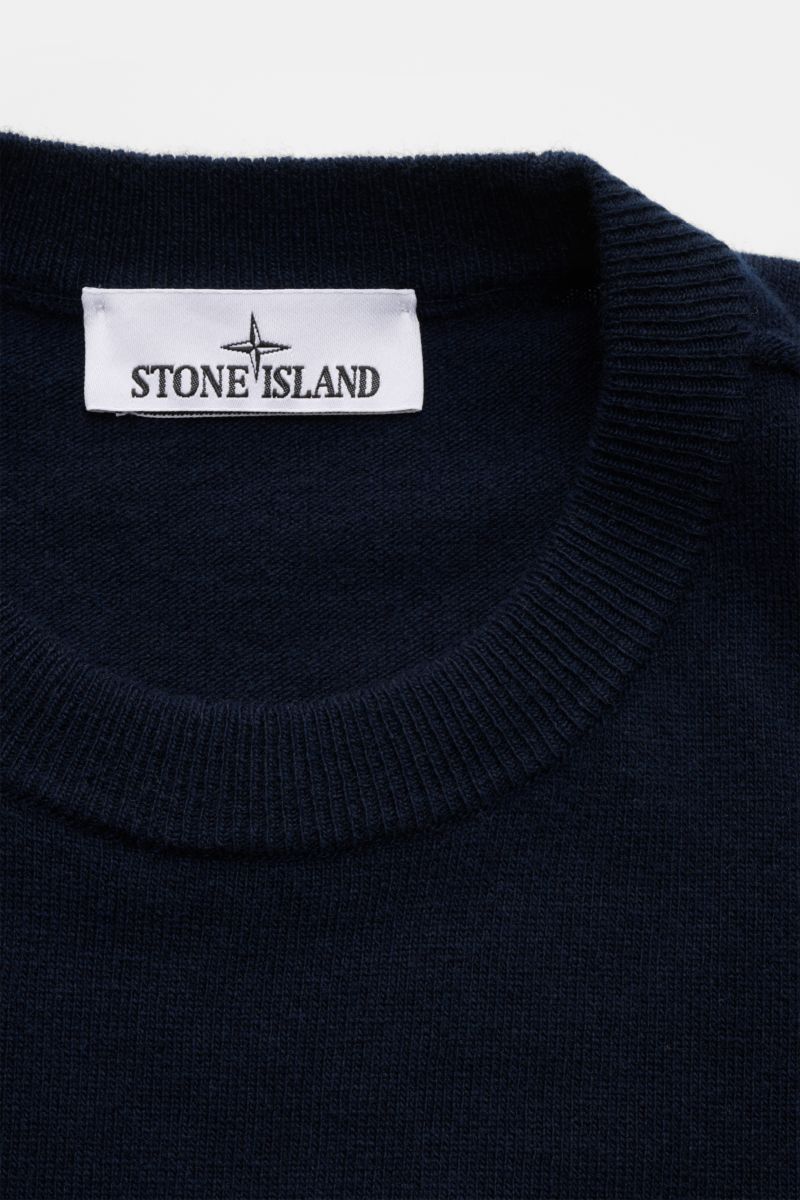 Close-up front view of the Stone Island Crew neck jumper navy showing the ribbed crew neck collar and brand label. 

A timeless piece from STONE ISLAND: If you want to create a warm, sporty look, you can’t go wrong with this classic crew neck jumper in