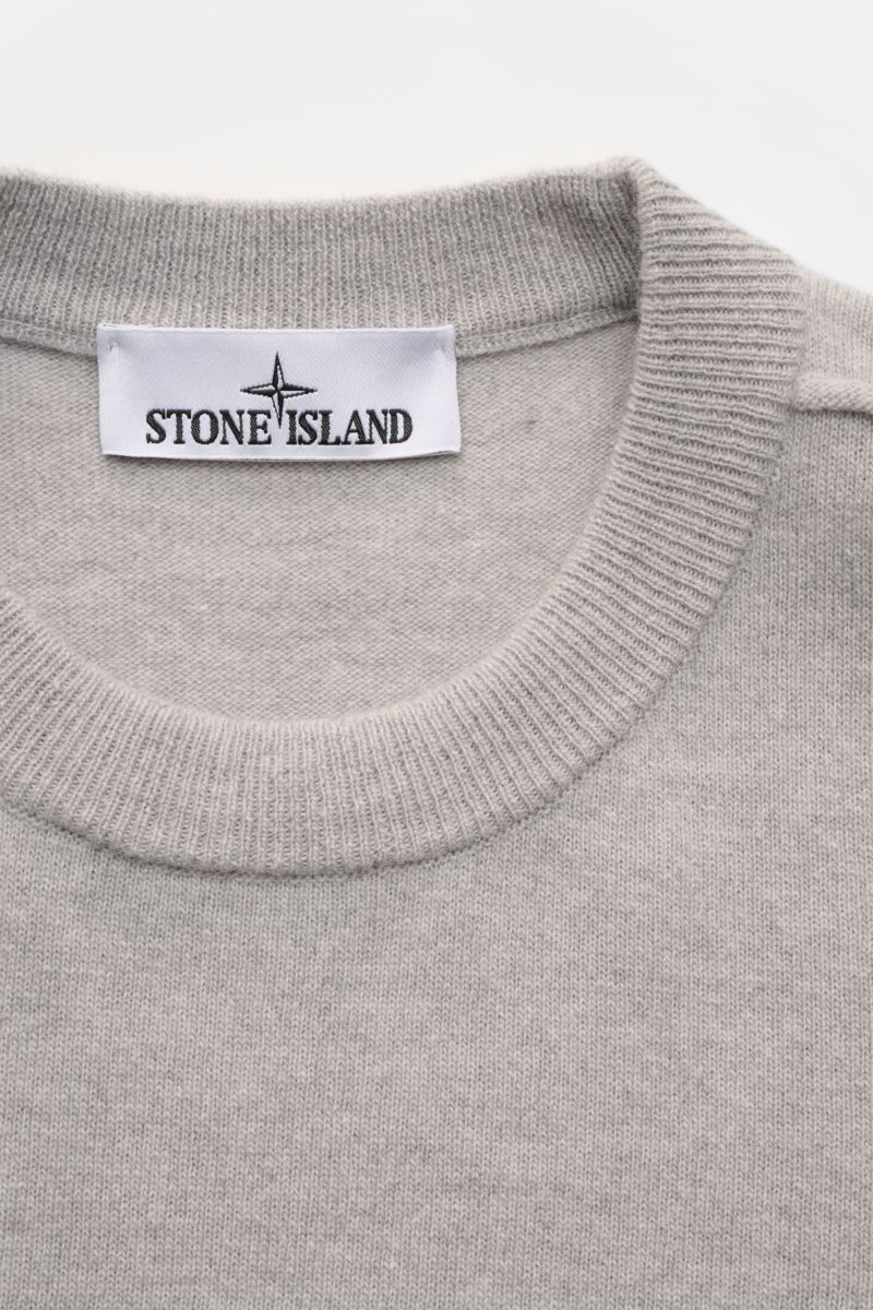 Close-up top-down view of Stone Island Crew neck jumper grey showing fine knit, elasticated ribbed crew neck, and white label with black logo.

Description: 
A timeless piece from STONE ISLAND: If you want to create a warm, sporty look, you can’t go wr