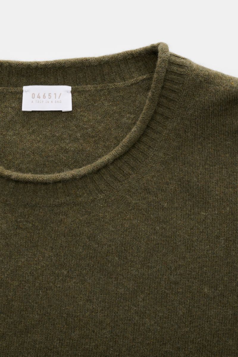 Close-up front view of the olive 04651/ A trip in a bag Crew neck jumper 'Boiled Crew' showing fine knit texture and ribbed crew neck. Stylish comfort for cold days: This crew neck jumper by 04651/ A TRIP IN A BAG is a versatile piece with timeless elegan