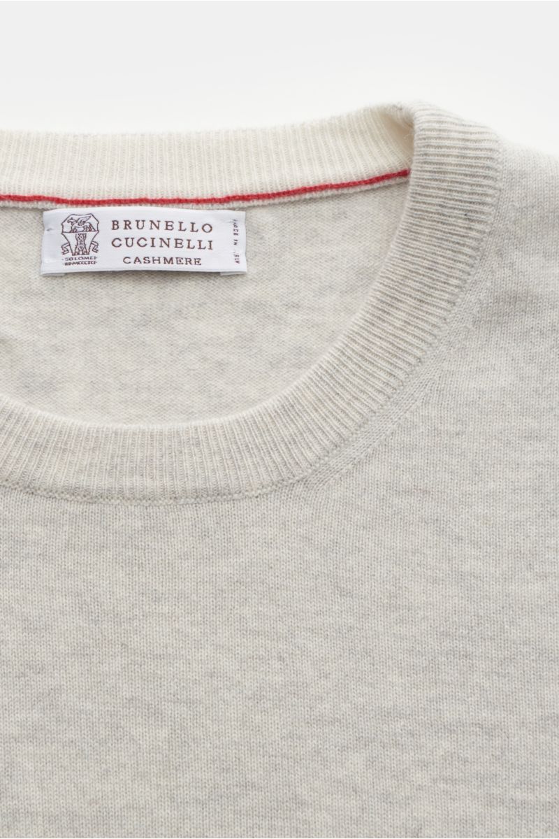 Close-up front view of Brunello Cucinelli Cashmere crew neck jumper light grey showing fine knit, narrow contrasting borders, and ribbed bands.

This luxurious cashmere jumper with crew neck by BRUNELLO CUCINELLI is a versatile essential that is not ju