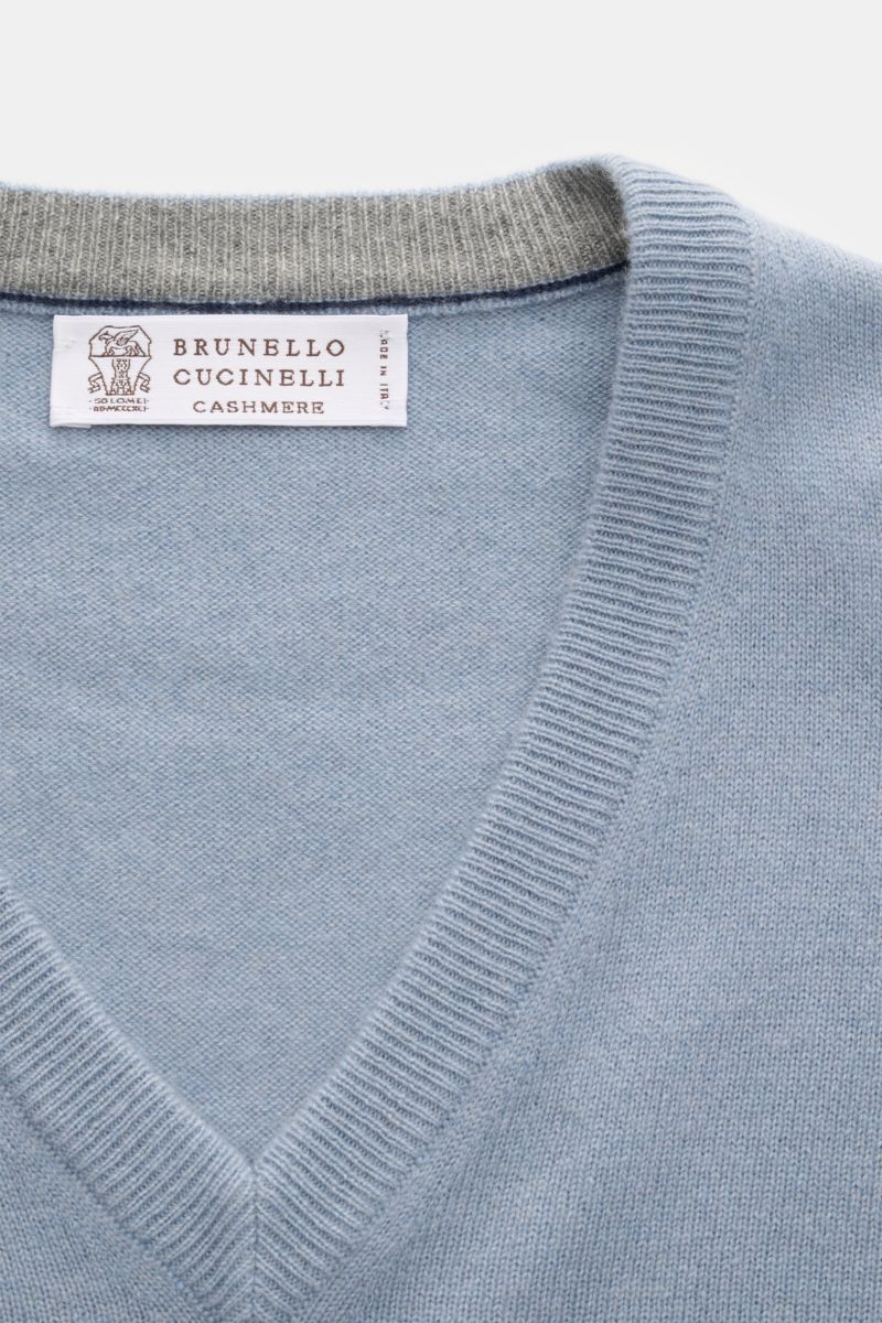 Nahaufnahme des rauchblauen Brunello Cucinelli Cashmere V-Neck Pullovers mit feinem Strickbild, schmalen Kontrastkanten und V-Ausschnitt.