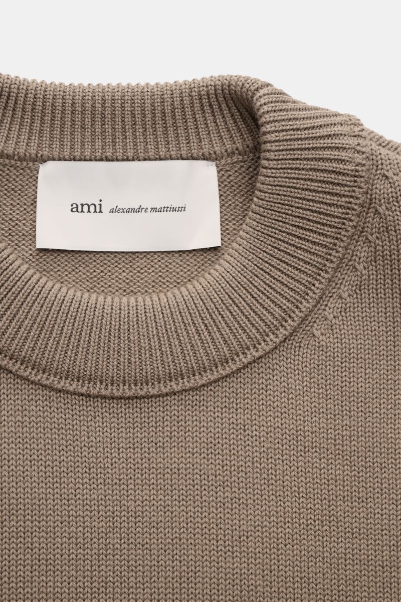 Nahaufnahme von oben auf den graubraunen Ami Paris Rundhalspullover 'ADC' mit mittelfeinem Strickbild, Rundhalsausschnitt und eingestricktem Logo.