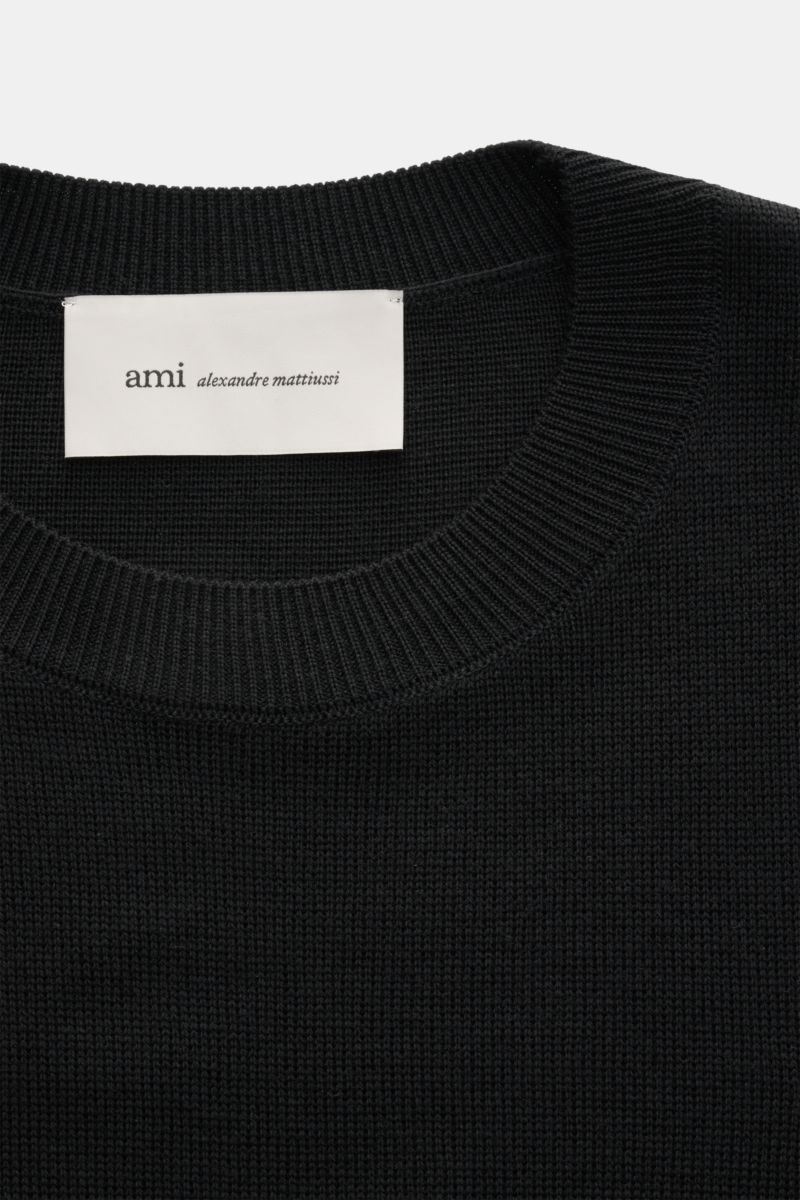 Close-up front view of Ami Paris Merino crew neck jumper black showing fine knit texture, ribbed crew neck, and logo stitching.

Description:  
Timeless basic: The AMI PARIS crew neck jumper made from pure merino wool is a comfortable companion for off