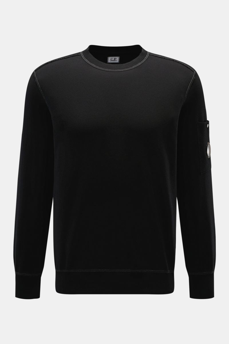 Front view of C.P. Company Crew neck jumper black in fine knit cotton with contrasting stitching and sleeve pocket with lens detail. 

