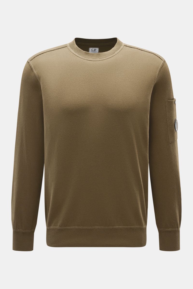 Front view of C.P. Company Crew neck jumper olive in fine knit cotton, featuring slim fit, ribbed cuffs, and a sleeve pocket with lens detail. 
