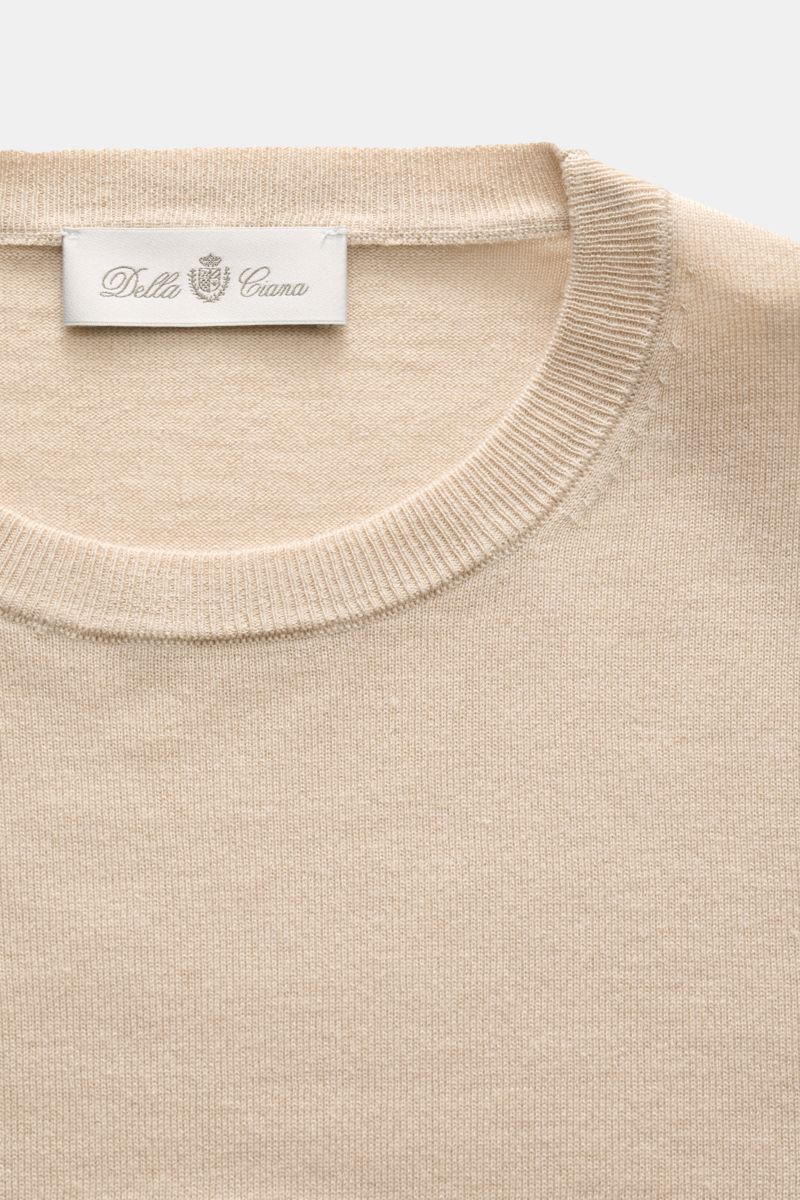 Close-up front view of the beige Della Ciana Feinstrick-Rundhalspullover 'Girocollo' showing its fine knit texture, round neckline, ribbed collar, and label, made from a soft silk and cashmere blend with a slim fit and lightweight quality. 