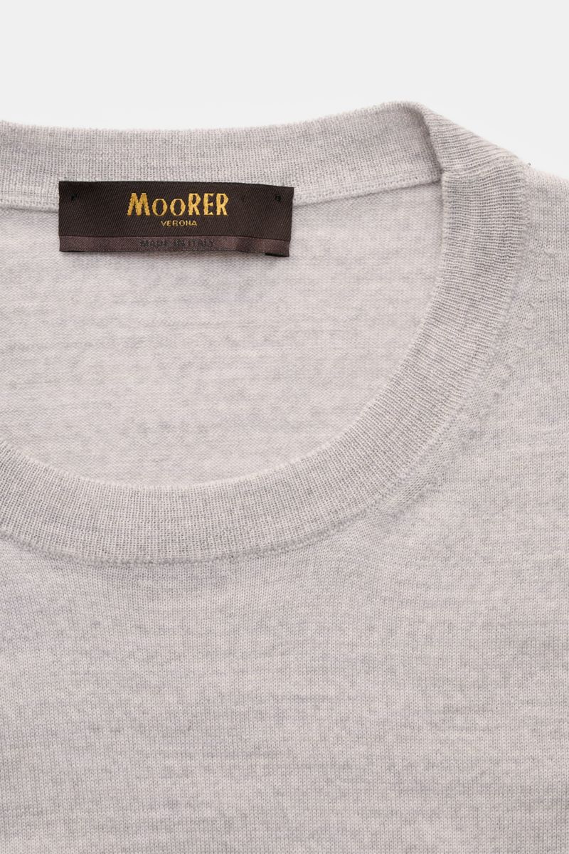 Close-up front view of the gray melange Moorer Rundhalspullover 'Orvieto' with round neckline and fine wool knit.  
Puristische Raffinesse: In feinem Schurwollstrick gefertigt, verbindet der Rundhalspullover von MOORER höchste Handwerkskunst mit klassi