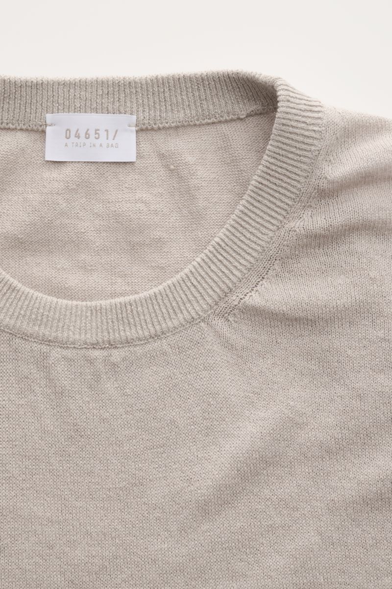 Close-up top view of 04651/ A trip in a bag Fine knit short sleeve jumper 'Pocket Tee' taupe showing crew neck and fine linen-cotton knit.

Description: Lightness you can feel: The fine knit short sleeve jumper 'Pocket Tee' by 04651/ A TRIP IN A BAG in