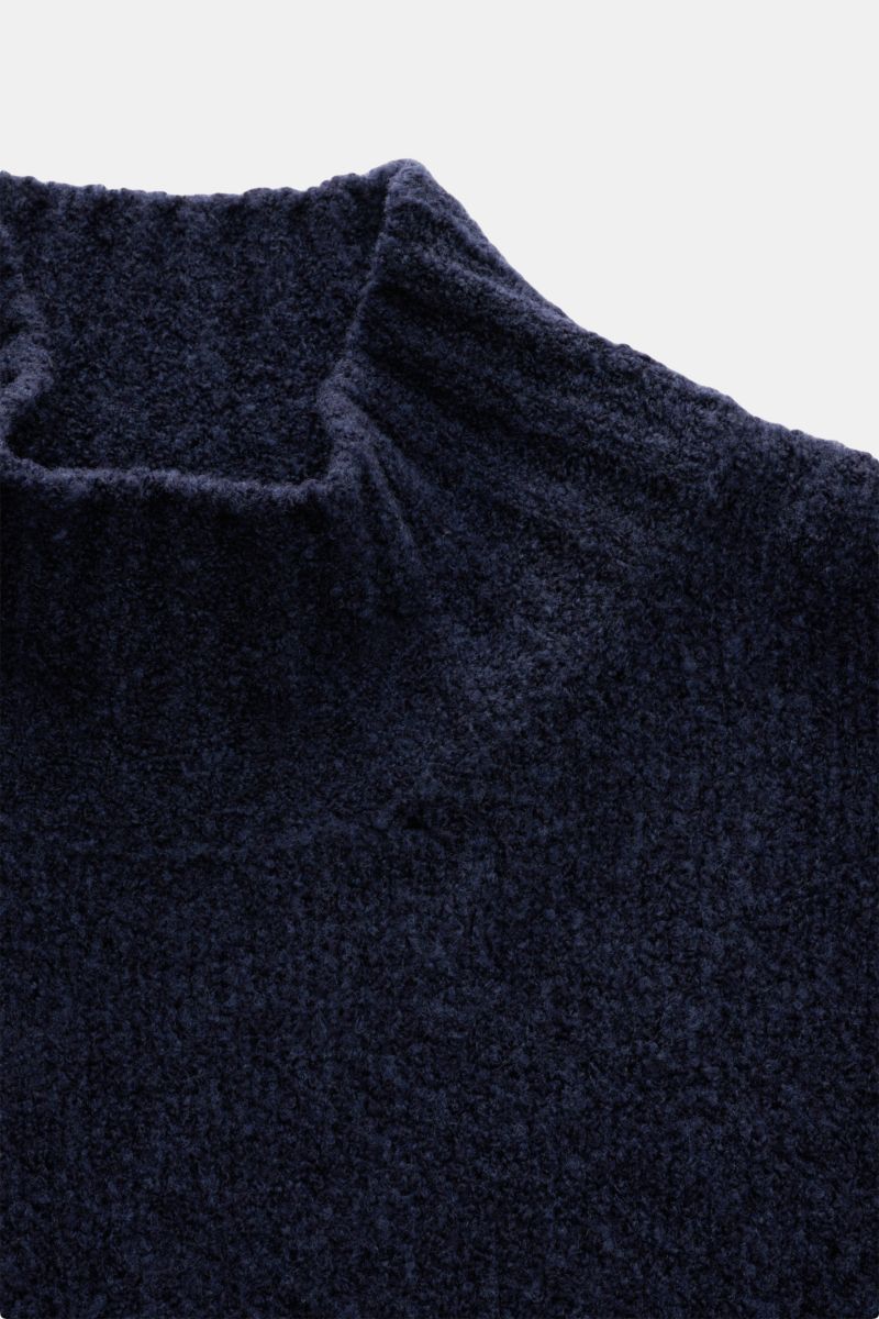 Close-up front view of the 04651/ A trip in a bag Mock neck jumper 'Grainy' navy melange showcasing its warm wool blend bouclé knit texture and high rib knit collar.

For modern looks: The jumper 'Grainy' by 04651/ A TRIP IN A BAG is made of a warm woo