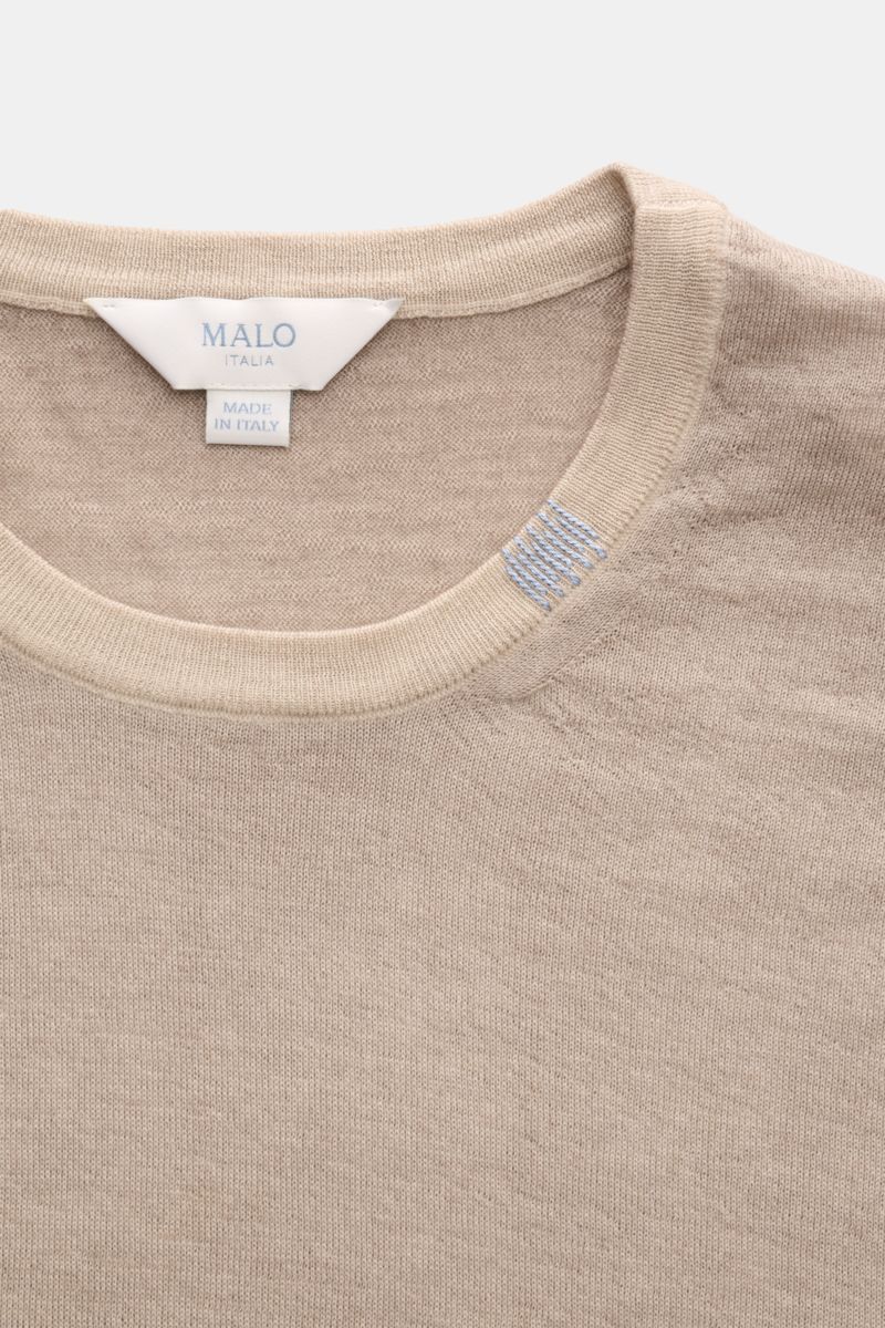 Close-up front view of Malo Cashmere crew neck jumper beige mottled, showing fine knit fabric, ribbed crew neck, and embroidered detail.

Description: An essential for cooler days: This cashmere jumper by MALO features fine fabric and is a stylish part