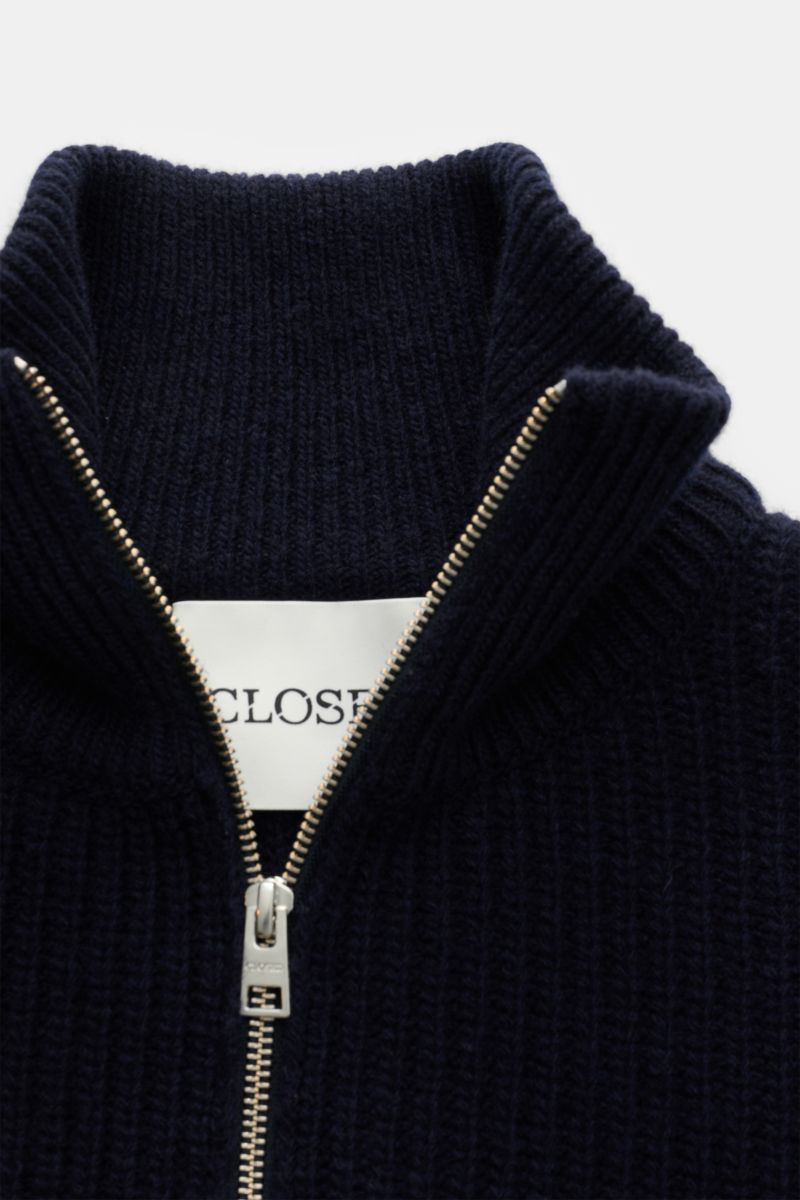 Nahaufnahme des Closed Troyer navy von oben fotografiert, Patentstrick aus reiner Wolle, schwere Qualität, grobes Strickbild, leicht griffige Haptik, Regular Fit, Rippstrickkragen mit Zipper, breite Rippbündchen.