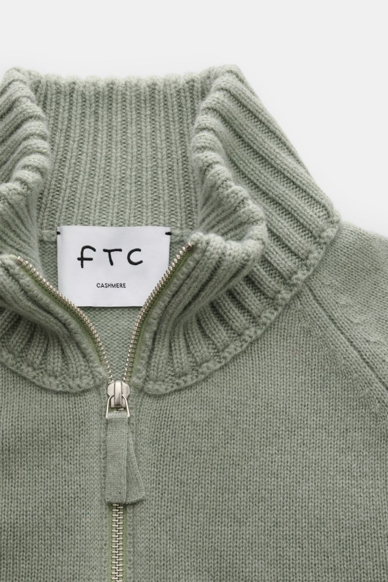 Close-up top-down view of the FTC Cashmere half-zip jumper grey-green showing the ribbed collar, zipper, and soft knit texture.

Stay cosy and warm in the colder months with this timeless half-zip jumper by FTC made of high-quality Fair Trade cashmere.