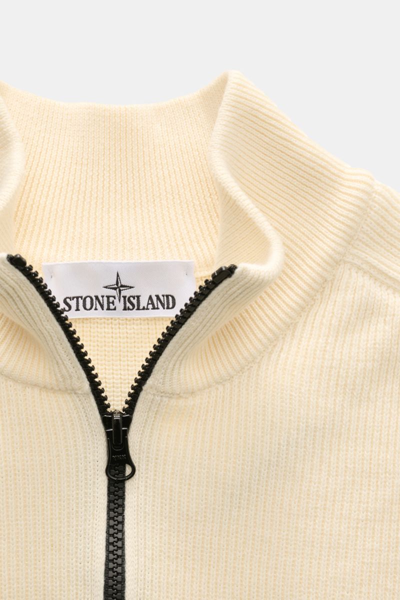 Nahaufnahme des Stone Island Troyer pastellgelb aus Baumwollstrick, mit Rippstrickkragen, halbem Zipper und sichtbarem Markenlabel.
