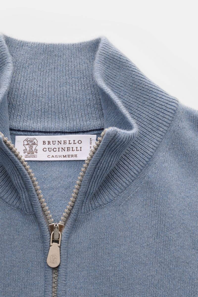 Brunello Cucinelli Cashmere Troyer rauchblau shown from a close-up top front view, featuring a high collar with zipper, fine knit, soft texture, and subtle contrast edges. Sportives Freizeit-Essential made in Solomeo: Der Troyer aus reinem Cashmere von