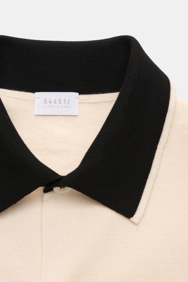 Close-up front view of 04651/ A trip in a bag Short sleeve knit shirt 'Colour Block' cream/black with black collar and cream body.

An eye-catching piece for summer: This short sleeve knit shirt by 04651/ A TRIP IN A BAG has a distinctive colour block 