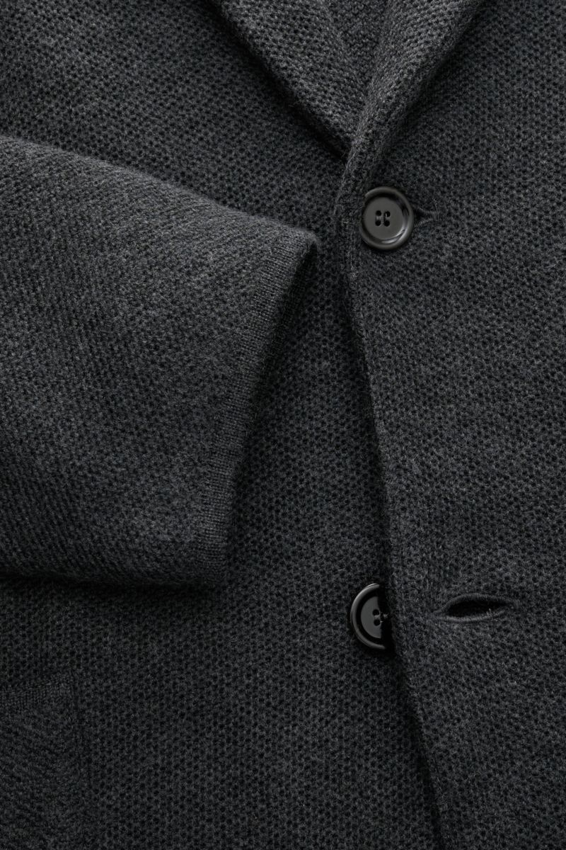 Nahaufnahme aus schräger Perspektive des dunkelgrau melierten Lardini Strickblazers mit Slim Fit, weichem Woll-Seide-Cashmere-Mix, zwei Knöpfen und strukturierter Oberfläche.