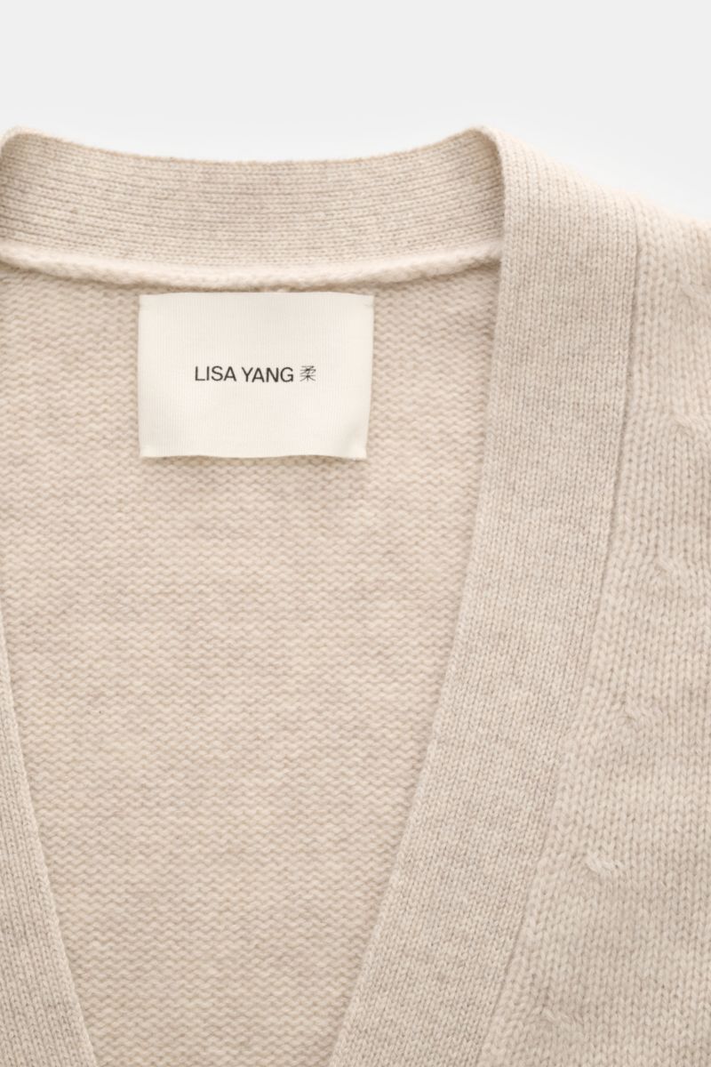 Nahaufnahme des Lisa Yang Cashmere Cardigan 'Wilson' sand meliert mit V-Ausschnitt, reiner Cashmere, weichem Griff, mittelfeinem Strickbild, Regular Fit, Vier-Knopf-Leiste, aufgesetzten Hüfttaschen und Rippbündchen.