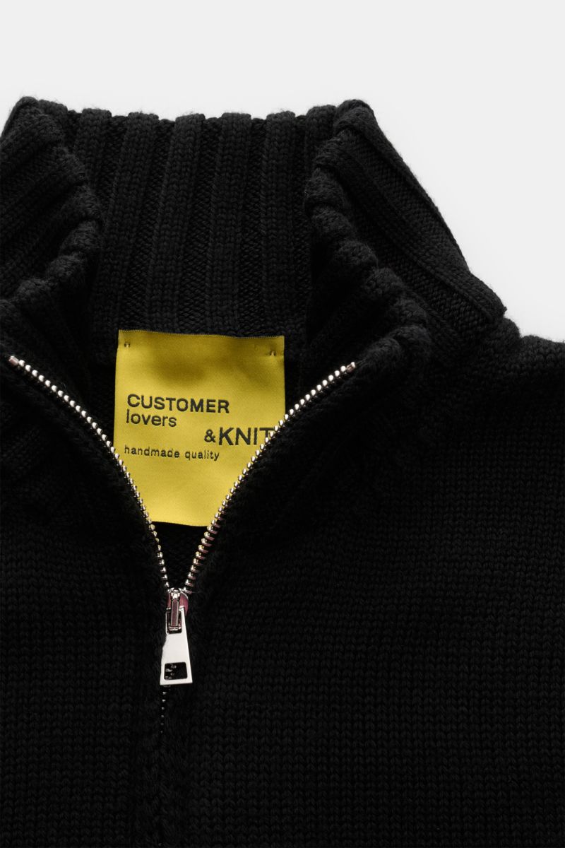 B.F. Knitwear Merino Strickjacke schwarz, Nahaufnahme von oben, weicher Merinowolle Slim Fit mit Stehkragen, Zwei-Wege-Reißverschluss, Rundhalsausschnitt, Rippbündchen.