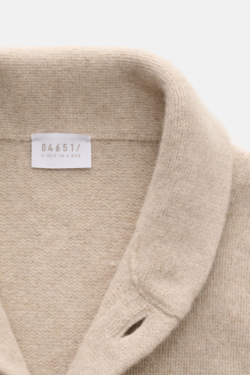 Nahaufnahme von Schalkragen und Label des 04651/ A trip in a bag Cardigan 'Knit Overjacket' beige meliert aus weichem Woll-Cashmere mit mittelfeinem Strick.