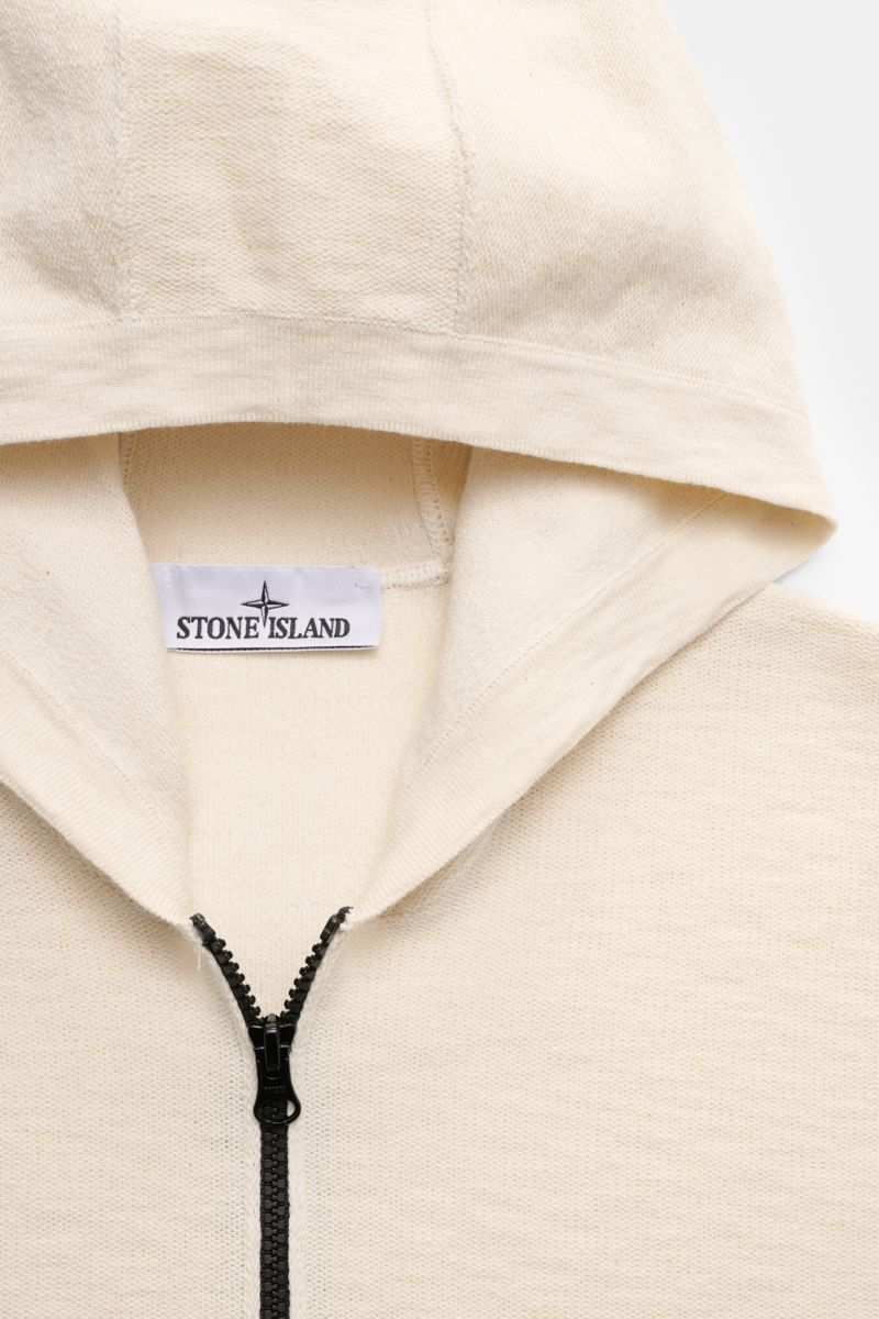 Close-up front view of Stone Island Sweatjacke creme hoodie with black zipper, showing creamy links knit texture and Stone Island label inside.

Description: Strick mit Twist: Die sportive Jacke mit Kapuze im modernen Linksstrick von STONE ISLAND wird 