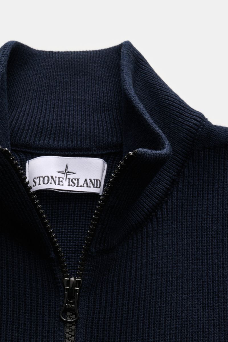 Close-up front view of Stone Island Strickjacke 'Rib' navy cardigan showing ribbed knit cotton fabric, two-way zipper, and stand-up collar.

Zeitloses Layering-Piece: Die Strickjacke von STONE ISLAND wird mit ihrem Rippstrick-Design aus reiner Baumwoll