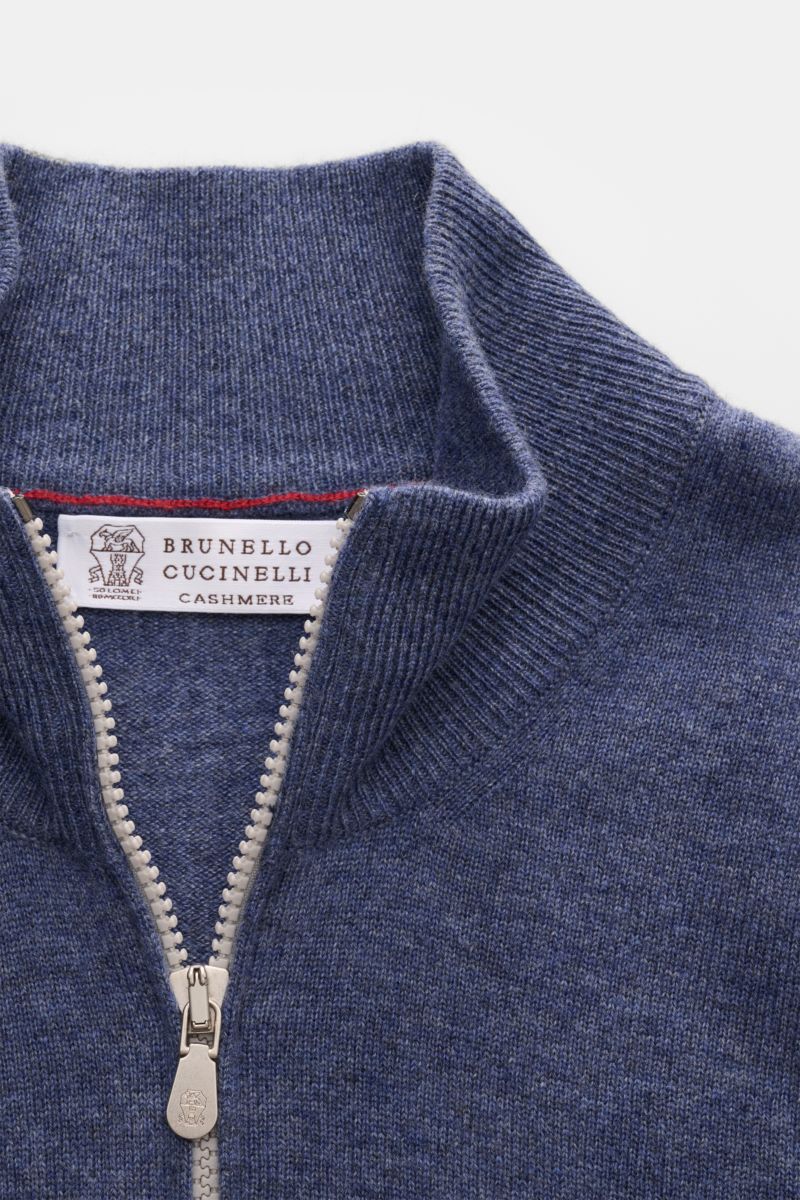 Close-up front view of Brunello Cucinelli Cashmere Strickjacke blau meliert with a two-way zipper, fine knit, and ribbed collar.

Luxus für die Freizeitgarderobe bietet BRUNELLO CUCINELLI mit dieser Strickjacke aus geschmeidigem Cashmere, veredelt mit 