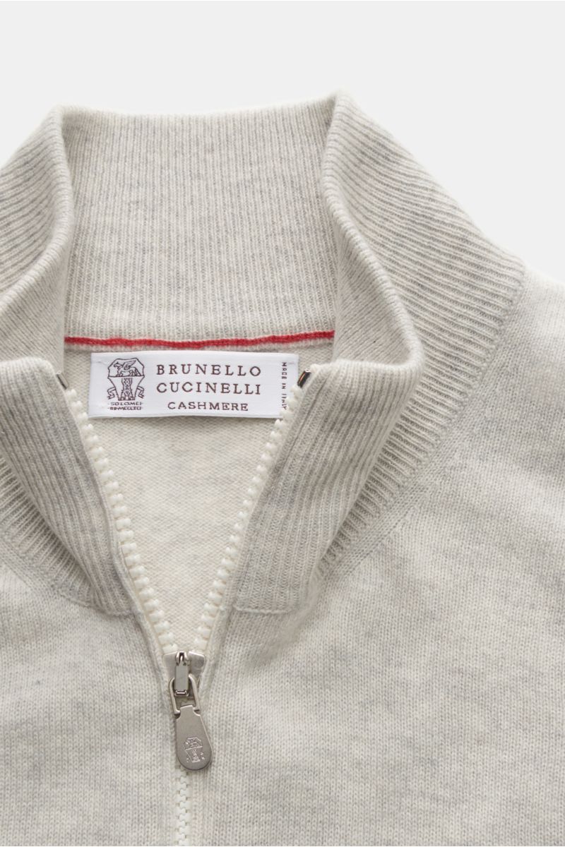 Close-up front view of Brunello Cucinelli Cashmere Strickjacke hellgrau meliert with ribbed stand collar and silver two-way zipper.

Luxus für die Freizeitgarderobe bietet BRUNELLO CUCINELLI mit dieser Strickjacke aus geschmeidigem Cashmere, veredelt m