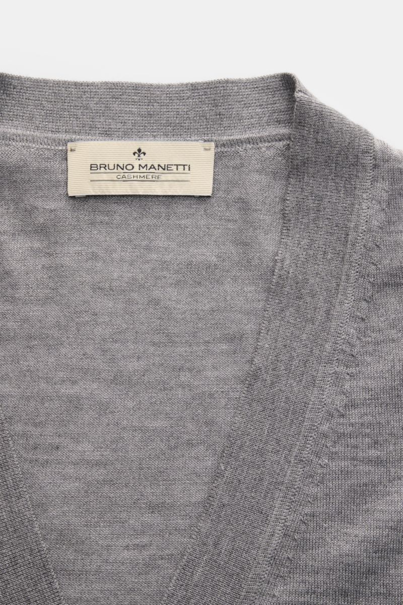Close-up front view of the Bruno Manetti Cashmere-silk cardigan grey mottled showing fine knit V-neck and label. Luxury you can feel on your skin: This fine knit cardigan by BRUNO MANETTI has an exceptionally soft feel and timeless elegance. The luxurious