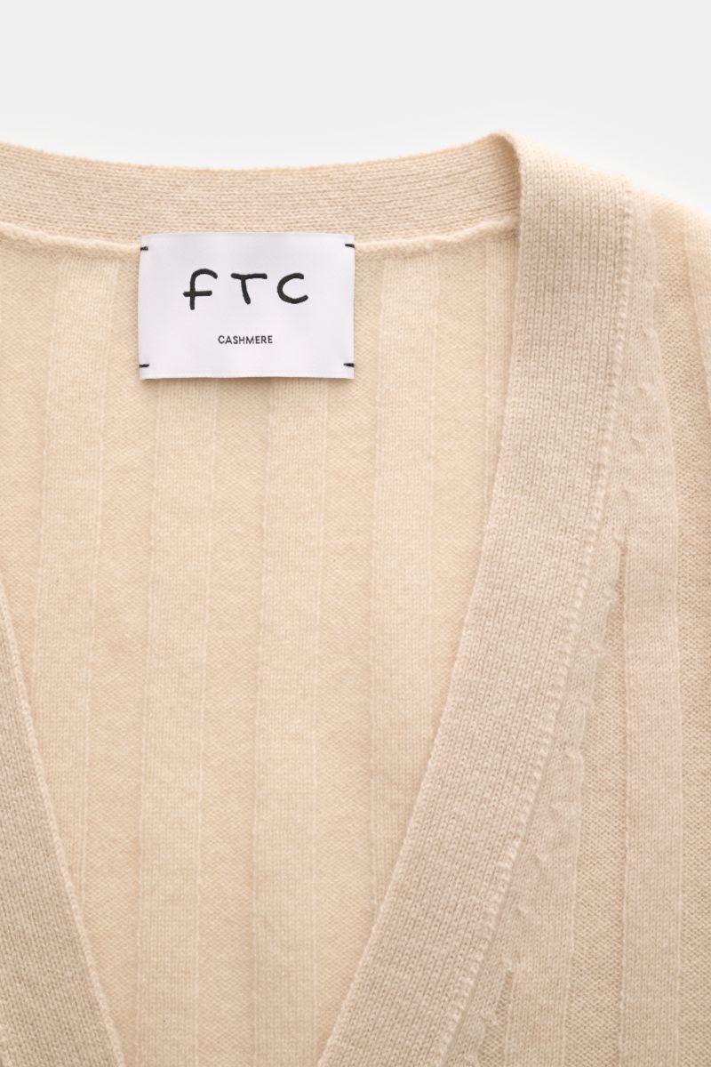 Close-up front view of FTC Cashmere cardigan beige showing wide rib knit, V-neck, and fine knit texture.

This luxurious cardigan by environmentally friendly knitwear label FTC is a soft essential made of pure fair trade cashmere in a college design an