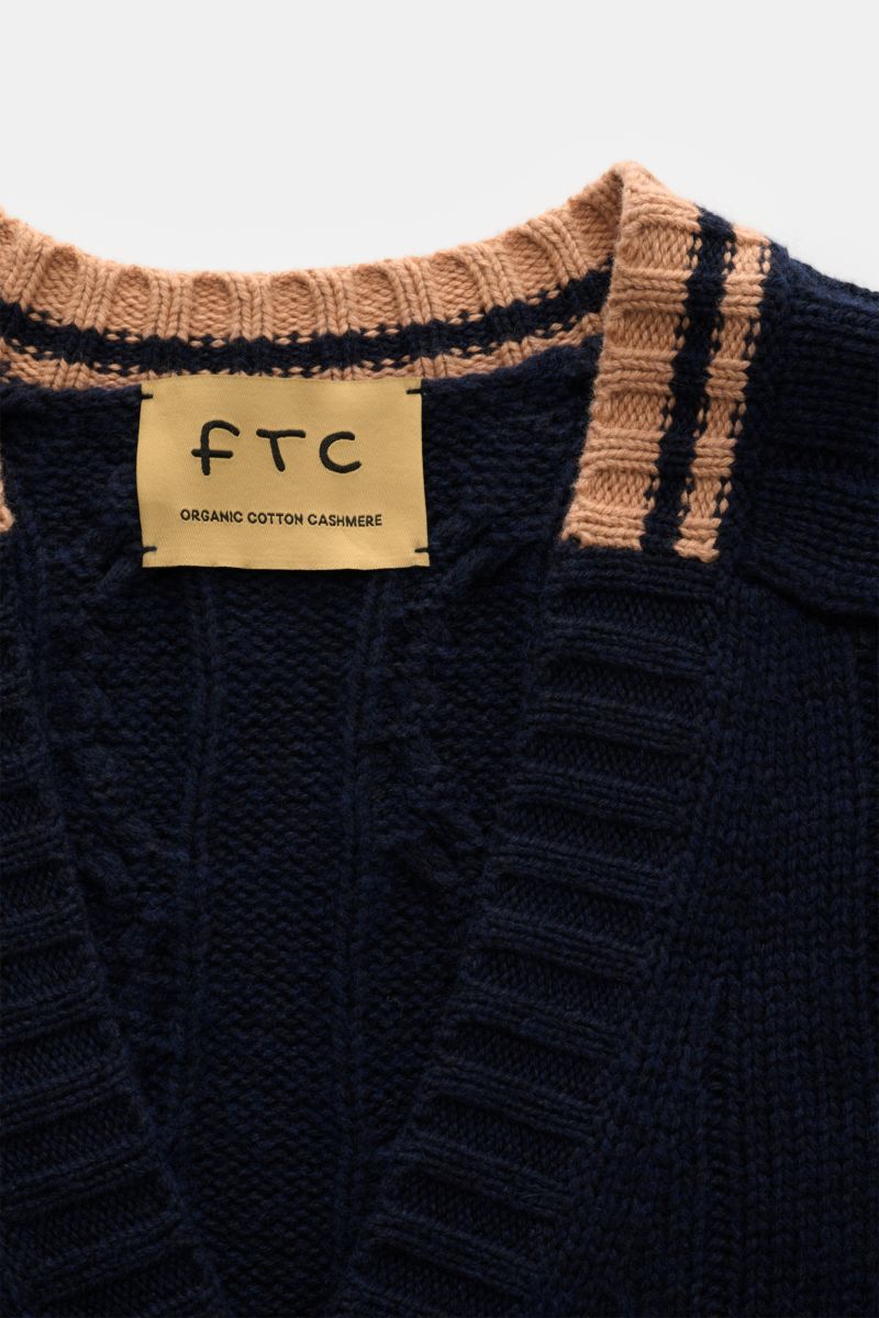 Nahaufnahme des FTC Cardigan navy von oben, zeigt V-Ausschnitt mit Zopfstrick, breite Kontrastkanten, weicher Bio-Baumwolle-Cashmere-Mix.