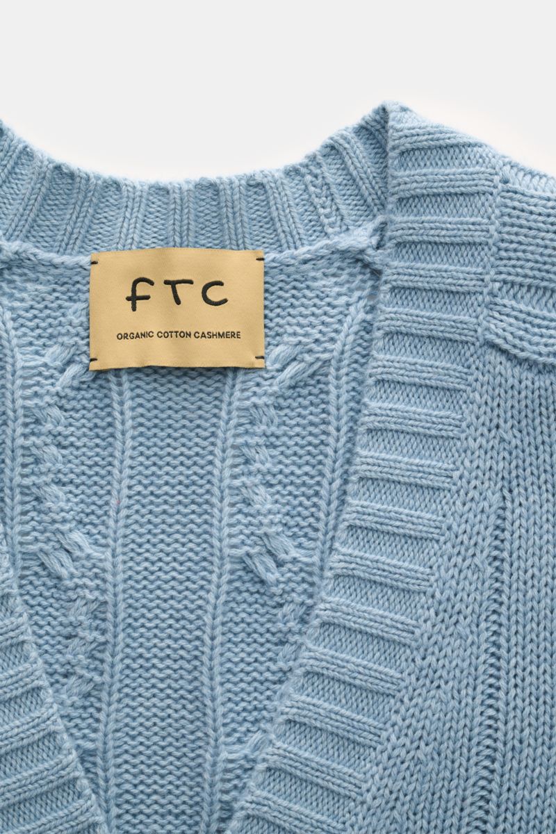 Nahaufnahme des FTC Cardigan hellblau mit Zopfstrick-Design, V-Ausschnitt und weichem, mittelgrobem Strick aus Bio-Baumwolle und Fair-Trade-Cashmere.