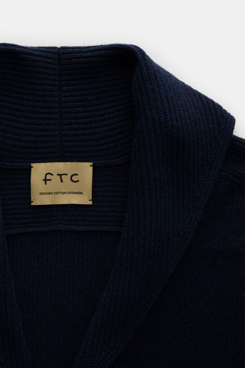 Nahaufnahme des FTC Cardigan navy von FTC mit Schalkragen, V-Ausschnitt, mittelfeinem Strickbild aus Baumwolle und Fair-Trade-Cashmere.