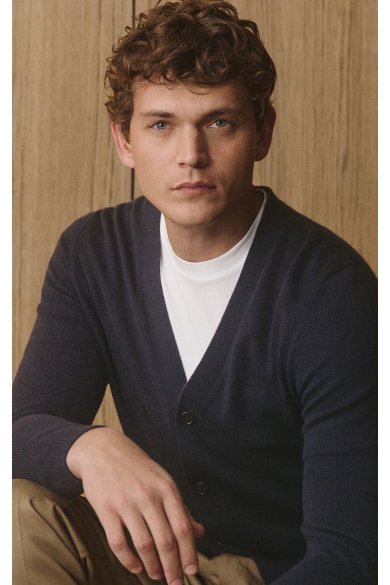 Junger Mann frontal sitzend, trägt von Braun Cashmere Cardigan navy aus mongolischem Cashmere, Slim Fit, fünf Knöpfe, weicher Griff.