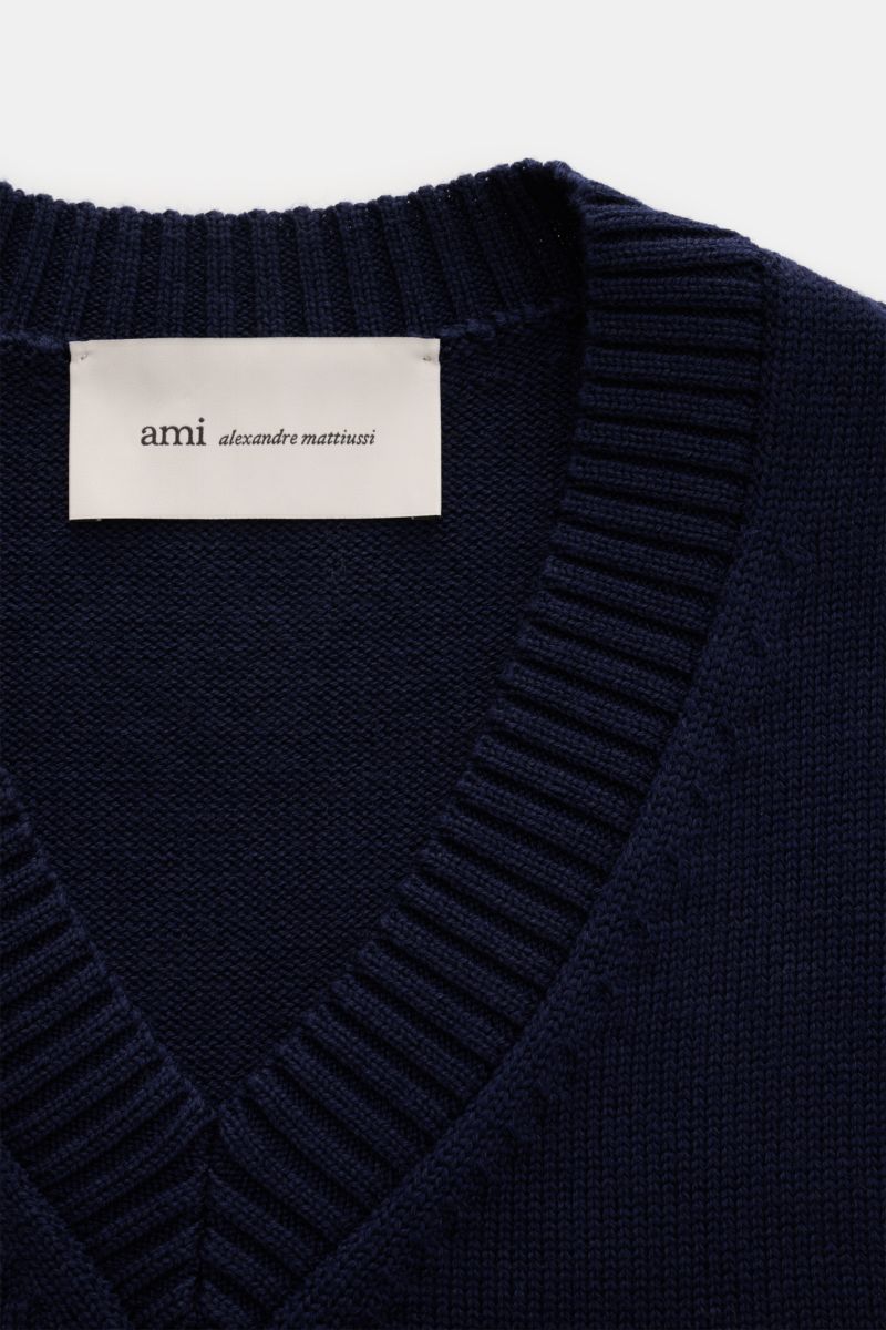 Close-up front view of the Ami Paris V-Neck Pullunder navy showing knit texture, ribbed V-neck collar, and brand label.

Layering-Piece von AMI PARIS: Der ikonische Pullunder mit V-Neck und typisch abgestepptem 'Ami'-Logo wurde aus Wolle und Baumwolle 