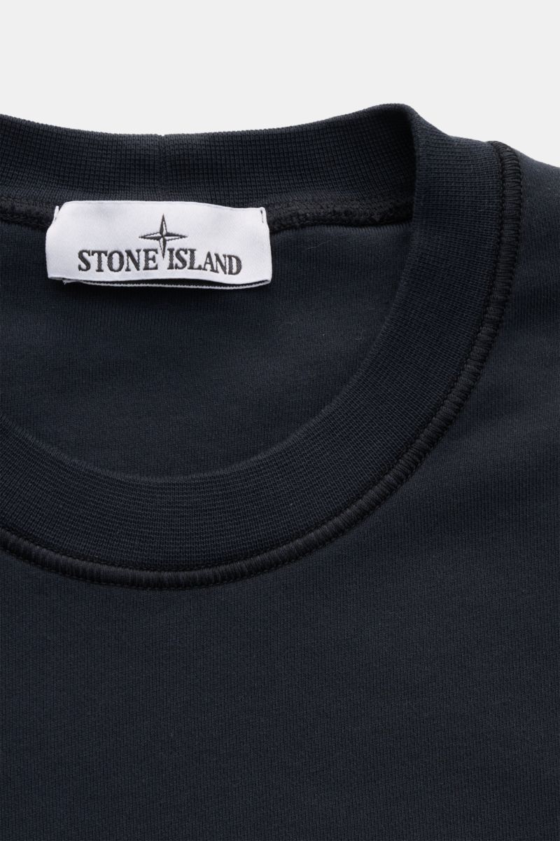 Nahaufnahme von Stone Island Rundhals-Sweatshirt navy, slim fit, garment dyed aus weicher Baumwolle mit Rippkragen, Label innen am Hals.